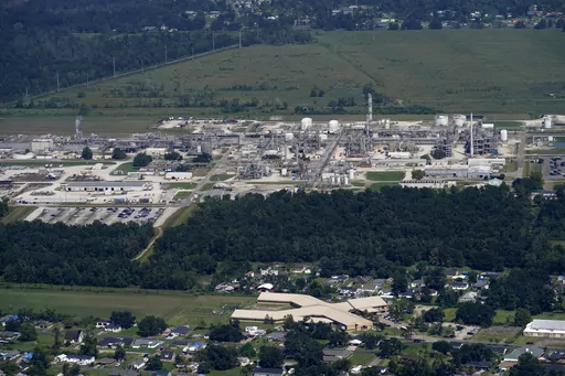 The Fifth Ward Elementary School and residential neighborhoods sit near the Denka Performance Elastomer Plant, back, in Reserve, La., Sept. 23, 2022. In what could prove a significant move for communities facing air pollution, the Environmental Protection Agency proposed on Thursday, April 6, 2023, that chemical plants nationwide measure certain hazardous compounds that cross beyond their property lines and reduce them when they are too high. (AP Photo/Gerald Herbert, File)