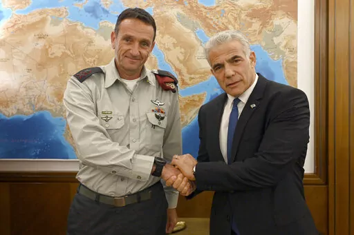In this photo provided by the Government Press Office, Israeli Prime Minister Yair Lapid, right, poses for a photo with Israel's next military chief Maj. Gen. Herzi Halevi in Jerusalem, Aug. 3, 2022. For the first time, a Jewish West Bank settler is set to take the reigns as chief of staff of Israel's military, the enforcer of the country's 55-year-old military occupation. Halevi’s rise caps the decades-long transformation of the settler movement from a small group of religious ideologues to a