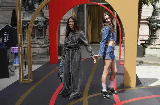 U.S. former swimmer Janet Evans, left, wears a creation by Veronique Leroy and her daughter Sydney Wilson wears a creation by Marine Serre and Sneex footwear, during the first gender equal Olympic Games fashion show, at the 2024 Summer Olympics in Paris, France, Sunday, July 28, 2024. To celebrate gender equality at the Olympics, PARITY Paris hosted a runway show in conjunction with the Coca-Cola House. (AP Photo/Michel Euler)