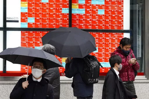 A person watches an electronic stock board showing Japan's Nikkei 225 index at a securities firm on Jan. 24, 2023, in Tokyo. Asian stock markets were mixed Thursday, Jan. 26, 2023 amid hopes Western economies can avoid a recession despite higher interest rates to cool inflation. (AP Photo/Eugene Hoshiko, File)