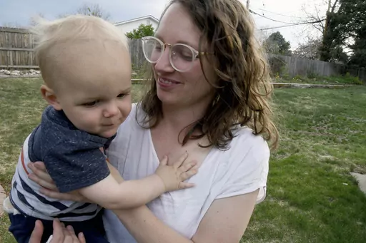 Sarah Perkins holds her 1-year-old son, Cal Sabey, at a relative's home in Centennial, Colo., Wednesday, May 3, 2023. Perkins and her husband are suing police and social workers in Massachusetts after their two young children were taken by the state's Department of Children and Families in July 2022. Hospital staff discovered that Cal had suffered a broken rib and flagged the couple for possible child abuse. The couple's lawsuit alleges constitutional violations including the unreasonable search