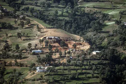 A view of the village of Ighran and the hill in which the rescue mission of 5-year-old Rayan had been taking place after he was stuck for several days, in Morocco's Chefchaouen province, Sunday, Feb. 6, 2022. Morocco's king says a 5-year-old boy has died after rescuers pulled him out of a deep well where he was trapped for four days. Moroccan King Mohammed VI expressed his condolences to the boy’s parents in a statement released by the palace. (AP Photo/Mosa'ab Elshamy)
