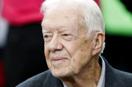 CORRECTS DATE OF CARTER CENTER'S STATEMENT TO FEB. 18, NOT FEB. 19 - FILE - Former President Jimmy Carter sits on the Atlanta Falcons bench before the first half of an NFL football game between the Falcons and the San Diego Chargers, Sunday, Oct. 23, 2016, in Atlanta. Carter, at age 98 the longest-lived American president, has had a recent series of short hospital stays. The Carter Center said in a statement Saturday, Feb. 18, 2023, that the 39th president has now “decided to spend his remaini
