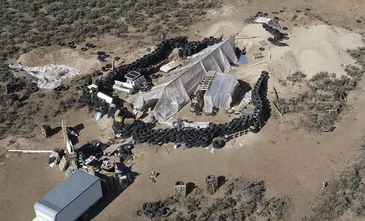 A ramshackle compound is seen in the desert area of Amalia, N.M., on Aug. 10, 2018. Two firearms charges were dismissed Thursday, Sept. 21, 2023, amid preparations for trial against an extended family arrested in a 2018 law enforcement raid on the compound in northern New Mexico and the discovery of a young boy's decomposed body. (AP Photo/Brian Skoloff, File)