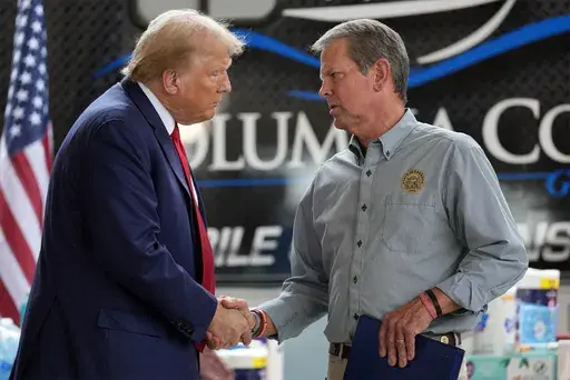 Republican presidential nominee former President Donald Trump shakes hands with Georgia Gov. Brian Kemp after speaking at a temporary relief shelter as he visits areas impacted by Hurricane Helene, Friday, Oct. 4, 2024, in Evans, Ga. (AP Photo/Evan Vucci)