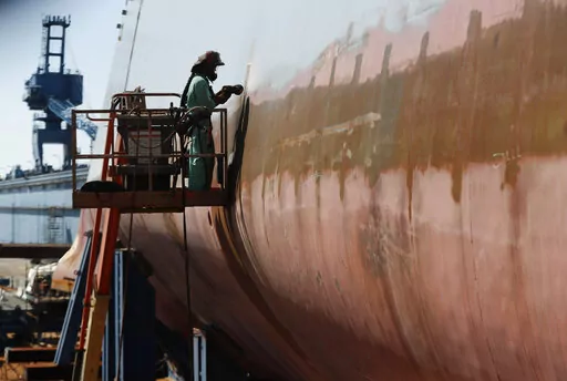 FILE — Welder Neal Larsen works on the hull of a Zumwalt-class destroyer Aug. 29, 2018, being built in the shipyard at Bath Iron Works in Bath, Maine. The U.S. Navy, following costly lessons after cramming too much new technology onto warships and speeding them into production, is slowing down the design and purchase of its next-generation destroyer, and taking extra steps to ensure new technology like lasers and hypersonic missiles have matured before pressing ahead. (AP Photo/Robert F. Bukat