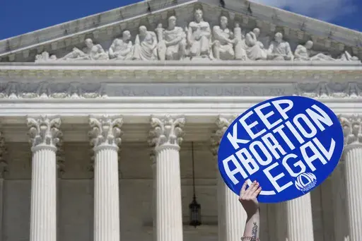 A person holds up a sign as abortion-rights activists and Women's March leaders protest as part of a national day of strike actions outside the Supreme Court, Monday, June 24, 2024, in Washington. A growing number of women said they've tried to end their pregnancies on their own by doing things like taking herbs, drinking alcohol or even hitting themselves in the belly, a new study suggests. Researchers surveyed reproductive-age women in the U.S. before and after the Supreme Court overturned Roe