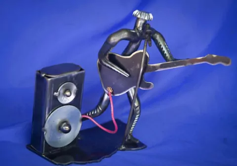 This guitarist is one of many pieces sculptor Lee Washington of Rolling Fork, Miss., has created from worn-out cotton picker spindles and other discarded metal pieces, Thursday, March 17, 2022 His gallery, Lee's Cotton Picker Art," is located at 149 Walnut St. in Rolling Fork. (Barbara Gauntt/The Clarion-Ledger via AP)