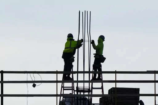 Construction workers work on a building in Philadelphia, Wednesday, Dec. 21, 2022. America’s employers added a solid 223,000 jobs in December, evidence that the economy remains healthy yet also a sign that the Federal Reserve may still have to raise interest rates aggressively to slow growth and cool inflation. (AP Photo/Matt Rourke, File)