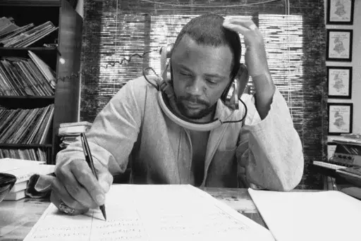 Composer Quincy Jones at his home studio in October 1974 writing music, listening to a recording on his headphones. (AP Photo/George Brich, File)