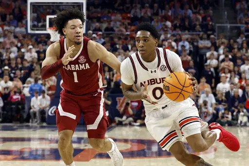 Auburn guard Tahaad Pettiford (0) drives to the basket around Alabama guard Mark Sears (1) during the second half of an NCAA college basketball game, Saturday, March 8, 2025, in Auburn, Ala. (AP Photo/Butch Dill)