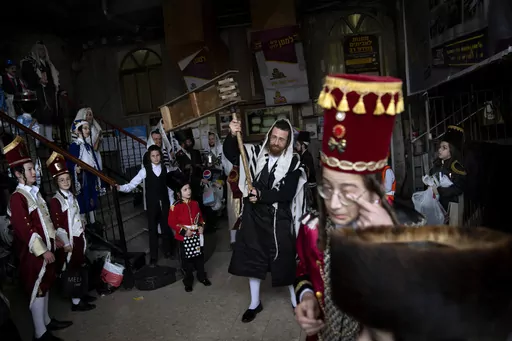 Jewish ultra-Orthodox men and children, some wearing costumes, celebrate the festival of Purim at a synagogue in Bnei Brak, Israel, March 17, 2022. Purim celebrates the biblical story of how a plot to exterminate Jews in Persia was thwarted, and thus is embraced as an affirmation of Jewish survival throughout history. For many Jews, it will have extra significance in 2024 during a war in Gaza triggered by the Oct. 7, 2023, attacks on Israel in which Hamas killed 1,200 people and took about 250 o