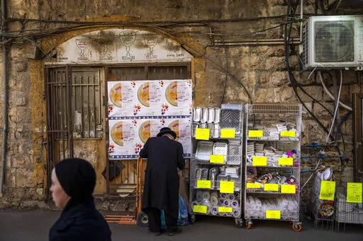 An ultra-Orthodox Jewish man buys disposable plastic dishes in Jerusalem's Mea Shearim neighborhood, Friday, Jan. 20, 2023. Israel's new government is in the process of repealing a new tax on single-use plastics. Ultra-Orthodox Jews, who have large families and use large quantities of disposable cups, plates and cutlery, say the tax unfairly targeted them. (AP Photo/Oded Balilty)