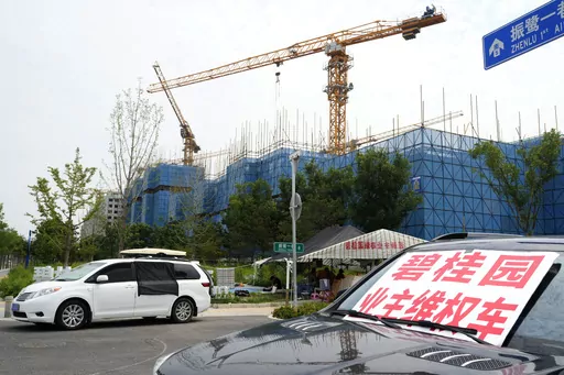 A car with a sign that reads, "Country Garden homeowners rights protections car," is parked near homeowners camping outside the Country Garden One World City project under construction on the outskirts of Beijing, Thursday, Aug. 17, 2023. China's government is trying to reassure jittery homebuyers after the major real estate developer missed a payment on its multibillion-dollar debt, reviving fears about the industry's shaky finances and their impact on the struggling Chinese economy. (AP Photo/