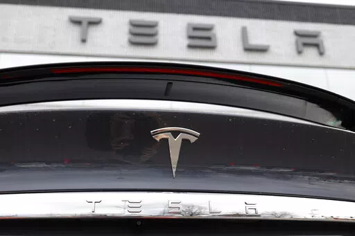 In this April 26, 2020 photo, the company logo shines off the rear deck of an unsold 2020 Model X at a Tesla dealership in Littleton, Colo. Tesla’s sales from April through June 2022 fell to their lowest quarterly level since last fall as supply chain issues and pandemic restrictions in China hobbled production of its electric vehicles. (AP Photo/David Zalubowski, File)