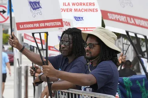 Dockworkers from Port Miami display signs at a picket line, Thursday, Oct. 3, 2024, in Miami. (AP Photo/Marta Lavandier)