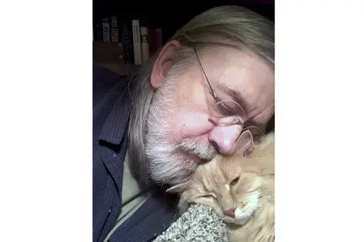 This undated self portrait made available by Little Brown publisher, shows author Caleb Carr and his cat Masha at his home in Cherry Plain, NY. Carr died of cancer Thursday, May 23, 2024, according to his publisher, Little, Brown and Company. (Caleb Carr/Little Brown via AP)