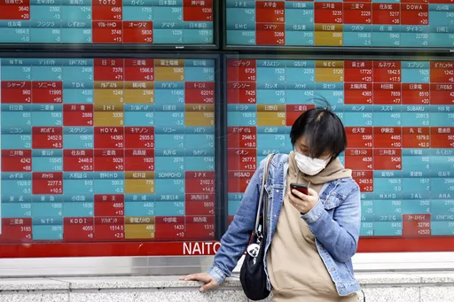 A person stands in front of an electronic stock board showing Japan's stock prices at a securities firm Friday, April 14, 2023, in Tokyo. Asian stock markets followed Wall Street higher on Friday after U.S. inflation eased in March and China reported unexpectedly strong exports.(AP Photo/Eugene Hoshiko)