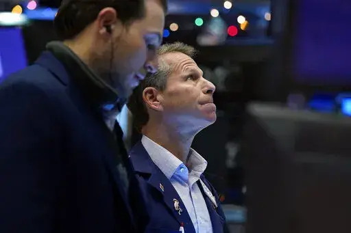 Trader Robert Charmak, right, works on the floor of the New York Stock Exchange, Tuesday, Dec. 7, 2021.  (AP Photo/Richard Drew, File)