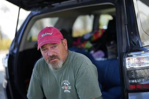 Snowbird William Wellema talks about his frustration at not being allowed on to the island to survey what remains of his trailer and recover whatever he can, following the passage of Hurricane Ian, in Fort Myers Beach, Fla., Friday, Oct. 7, 2022. Wellema drove down from New Jersey after the storm, but arrived to find the access bridge closed to all but emergency personnel. After four days living out of his car, he is considering crossing by kayak at night. (AP Photo/Rebecca Blackwell)