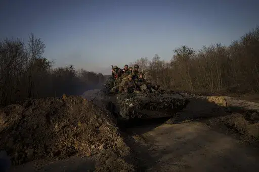 Ukrainian servicemen ride atop a tank near the town of Trostyanets, Ukraine, Monday, March 28, 2022. (AP Photo/Felipe Dana)