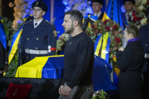 Ukrainian President Volodymyr Zelenskyy pays his respects to victims of a deadly helicopter crash during a farewell ceremony in Kyiv, Ukraine, Saturday, Jan. 21, 2023. Interior Minister Denys Monastyrsky, his Deputy Yevhen Yenin, State Secretary Yurii Lubkovych, national police official and the three crew members were killed in a helicopter crash on Wednesday in Kyiv suburbs of Brovary. (AP Photo/Efrem Lukatsky)