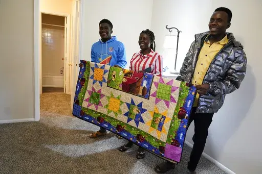 Refugees from Congo Sadock Ekyochi, from left, his wife Riziki Kashindi and her brother Kaaskile Kashindi pose for a photo inside their new apartment, Thursday, April 11, 2024, in Columbia, S.C. The American refugee program, which long served as a haven for people fleeing violence around the world, is rebounding from years of dwindling arrivals under former President Donald Trump. The Biden administration has worked to restaff refugee resettlement agencies and streamline the process of vetting a