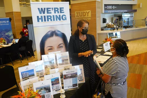 Marriott human resources recruiter Mariela Cuevas, left, talks to Lisbet Oliveros, during a job fair at Hard Rock Stadium, Friday, Sept. 3, 2021, in Miami Gardens, Fla. Federal Reserve policymakers at a meeting last month said the U.S. job market was nearly at levels healthy enough that the central bank's low-interest rate policies were no longer needed. That's according to minutes of the meeting released Wednesday, Jan. 5, 2022.  (AP Photo/Marta Lavandier, File)