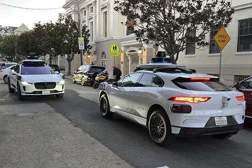 Two Waymo driverless taxis stop before passing one another on a San Francisco street on Feb. 15, 2023. (AP Photo/Terry Chea, File)