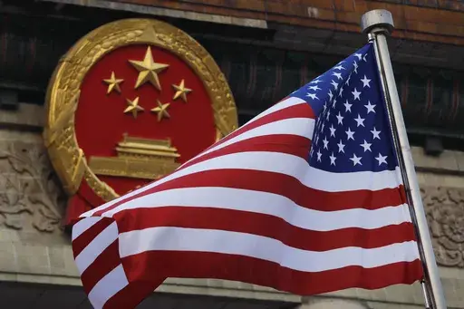 An American flag is flown next to the Chinese national emblem outside the Great Hall of the People in Beijing, Nov. 9, 2017. (AP Photo/Andy Wong, File)