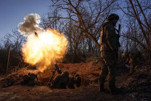 Ukrainian servicemen fire a 120mm mortar towards Russian positions at the frontline near Bakhmut, Donetsk region, Ukraine, Wednesday, Jan. 11, 2023. (AP Photo/Evgeniy Maloletka)