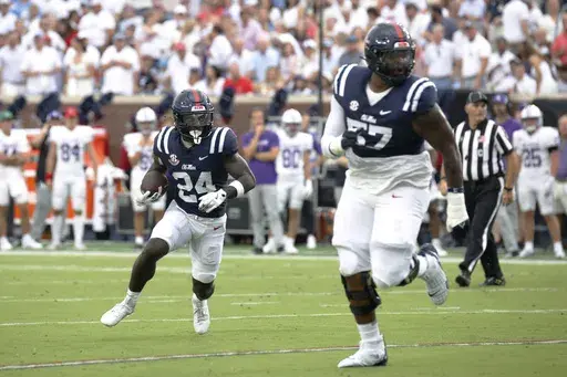 Mississippi running back Ulysses Bentley IV (24) runs the ball, while offensive lineman Micah Pettus (57) guards, during the first half of an NCAA college football game, against Furman, Saturday, Aug. 31, 2024, in Oxford, Miss. (AP Photo/Sarah Warnock)