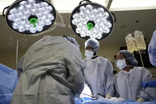 Meharry Medical College students Emmanuel Kotey, center, and Teresa Belledent, right, watch as the liver and kidneys are removed from an organ donor June 15, 2023, in Jackson, Tenn. They’re part of a novel pilot program to encourage more Black and other minority doctors-to-be to get involved in the transplant field, increasing the trust of patients of color. (AP Photo/Mark Humphrey)