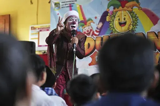 Yahya Edward Hendrawan, who is also known as 'Yahya the Clown', gives an Islamic religious class during a Ramadan event at an elementary school in Tangerang, Indonesia, Wednesday, March 19, 2025. (AP Photo/Dita Alangkara)