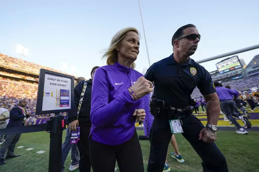 LSU national champion women's basketball head coach Kim Mulkey runs on the sideline before an NCAA college football game against Auburn in Baton Rouge, La., Saturday, Oct. 14, 2023. (AP Photo/Gerald Herbert)