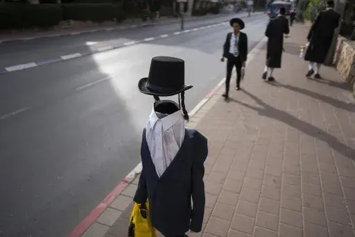 An ultra-Orthodox Jewish child walks through the streets in costume during the Purim festival celebrations in Bnei Brak, Israel, on Friday, March 14, 2025. (AP Photo/Oded Balilty)