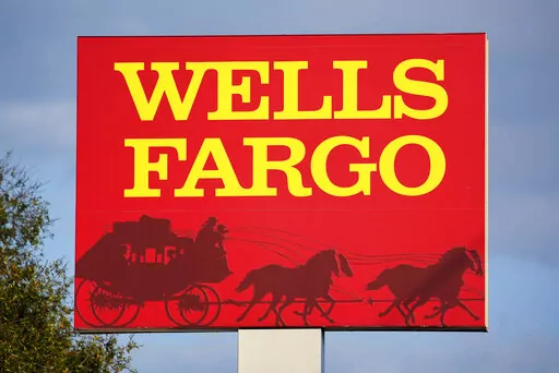 A Wells Fargo sign stands in front of a branch of the bank in Bradenton, Fla., Tuesday, Feb. 22, 2022. Consumer banking giant Wells Fargo is being ordered to pay $3.7 billion in fines and refunds to customers by U.S. government regulators, the largest fine to date against the bank. (AP Photo/Gene J. Puskar, File)
