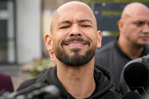 Andrew Tate reacts while speaking to media after checking in at a police station as part of his judicial control, which requires him to appear before judicial authorities in Romania when summoned, after returning from the United States, in Voluntari, Romania, Monday, March 24, 2025. (AP Photo/Vadim Ghirda, File)