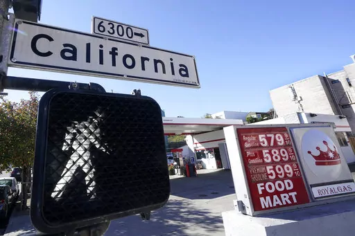 A California street sign is shown next to the price board at a gas station in San Francisco, on March 7, 2022. The average U.S. price of regular-grade gasoline shot up a whopping 79 cents over the past two weeks to $4.43 per gallon. Industry analyst Trilby Lundberg of the Lundberg Survey says Sunday, March 13, the new price exceeds by 32 cents the prior record high of $4.11 set in July 2008. Lundberg said gas prices are likely to remain high in the short term as crude oil costs soar amid global 