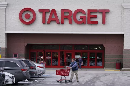 A shopper wheels a cart through the parking lot after making a purchase at the Target store, Monday, Feb. 27, 2023, in Salem, N.H. Target is recalling almost 5 million candles over laceration and burn hazards, according to a Thursday notice published by the U.S. Consumer Product Safety Commission.(AP Photo/Charles Krupa, File)