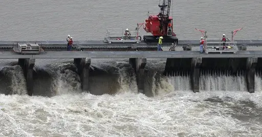 Workers open bays of the Bonnet Carre Spillway to divert rising water from the Mississippi River to Lake Pontchartrain, upriver from New Orleans, in Norco, La., May 10, 2019. (AP Photo/Gerald Herbert, File)