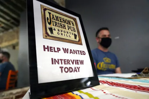 A hiring sign is placed at a booth for Jameson's Irish Pub during a job fair Wednesday, Sept. 22, 2021, in the West Hollywood section of Los Angeles.  In a surprising burst of hiring, America’s employers added 467,000 jobs in January 2022 in a sign of the economy’s resilience even in the face of a wave of omicron infections last month. (AP Photo/Marcio Jose Sanchez, File)