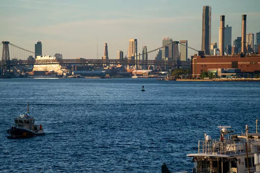 NYPD and Coast Guard boats patrol the East River outside the United Nations headquarters, Tuesday, Sept. 21, 2022, in New York. (AP Photo/Julia Nikhinson)