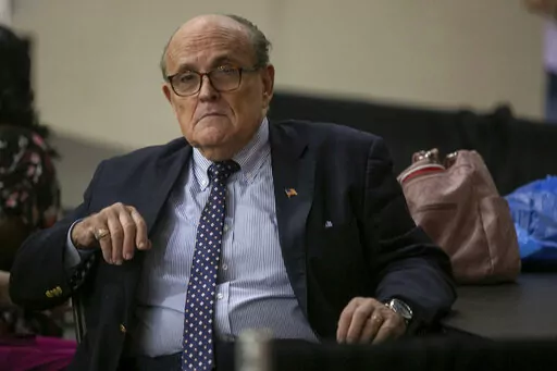 Former New York City Mayor Rudy Giuliani sits where delegate votes will be counted as nominee for statewide positions are introduced during the Michigan Republican convention at Devos Place in Grand Rapids, Mich., on Saturday, April 23, 2022. (Daniel Shular/The Grand Rapids Press via AP)