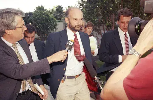 Former Exxon Valdez Capt. Joseph Hazelwood is surrounded by reporters as he leaves his re-licensing hearing in Long Beach, Calif., on July 25, 1990. Hazelwood, the captain of the Exxon Valdez oil tanker that ran aground more than three decades ago in Alaska, causing one of the worst oil spills in U.S. history, has died in July 2022, the New York Times reported. He was 75. (AP Photo/Alan Greth, File)
