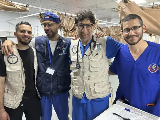 Dr. Ammar Ghanem, an ICU specialist from Detroit volunteering with the Syrian American Medical Society at one of Gaza's last functioning hospitals, second from right, poses on May 7, 2024, in Khan Younis, Gaza, with a Palestinian doctor and two other American doctors volunteering at the European General Hospital where they have been since early May. A group of 35 foreign doctors on a volunteer mission to help at the hospital, including 22 Americans, have been trapped in Gaza by Israel’s seizur