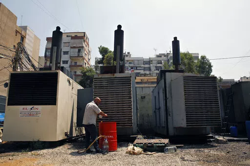 Mamdouh al-Amari refuels privately-owned diesel generators that provide power to homes and businesses, in the southern suburbs of Beirut, Lebanon, July 16, 2018. Internet services were disrupted in Lebanon Sunday, Jan. 16, 2022, because of diesel shortages, according to the state provider, adding another essential service to the list of casualties of the country’s snowballing economic crisis. (AP Photo/Bilal Hussein, File)