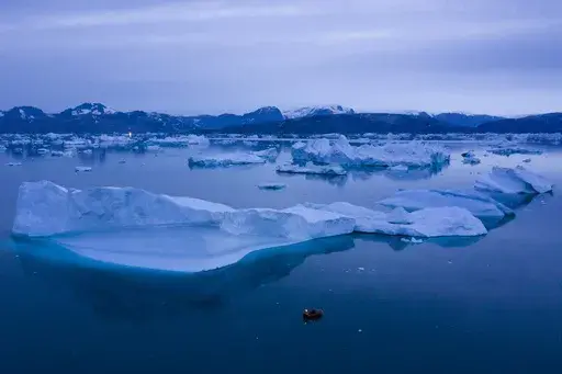 A boat navigates large icebergs near the town of Kulusuk, in eastern Greenland, on Aug. 15, 2019. (AP Photo/Felipe Dana, File)