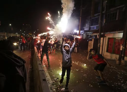 Youths light firecrackers and flares as they celebrate the end of the fasting month of Ramadan on a street in Jakarta, Indonesia, Tuesday, June 4, 2019. Islam follows a lunar calendar and so Ramadan and Eid cycle through the seasons. In 2024, the first day of Eid al-Fitr is expected to be on or around April 10; the exact date may vary among countries and Muslim communities. (AP Photo/Dita Alangkara, File)