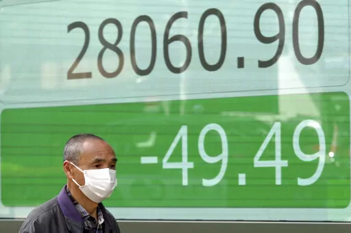 A man wearing a protective mask walks in front of an electronic stock board showing Japan's Nikkei 225 index at a securities firm Friday, March 25, 2022, in Tokyo. Asian stock markets fell Friday after Western governments promised new sanctions on Russia and President Vladimir Putin tried to prop up Moscow's sinking ruble by threatening to require Europe to use it to pay for gas exports. (AP Photo/Eugene Hoshiko)